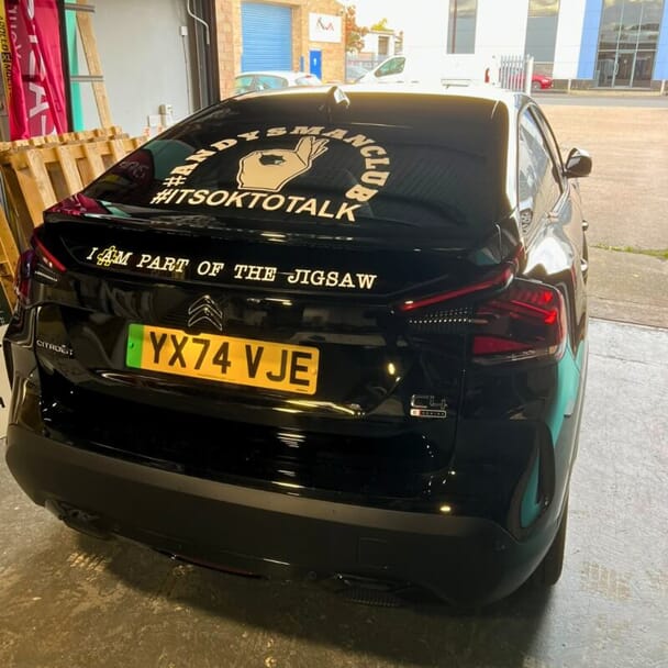 An image of yellow vehicle graphics on the back of a black vehicle.